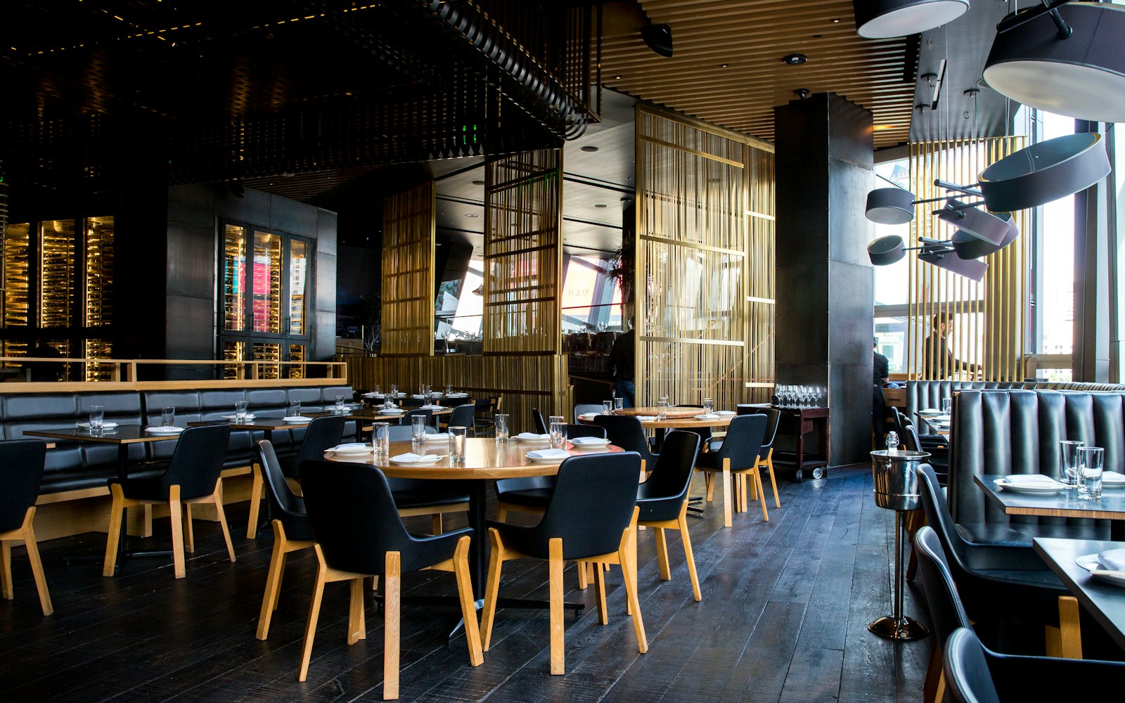 Salle de restaurant avec tables dressées, lumière tamisée et sièges en cuir, illustration pour choisir un restaurant en Suisse