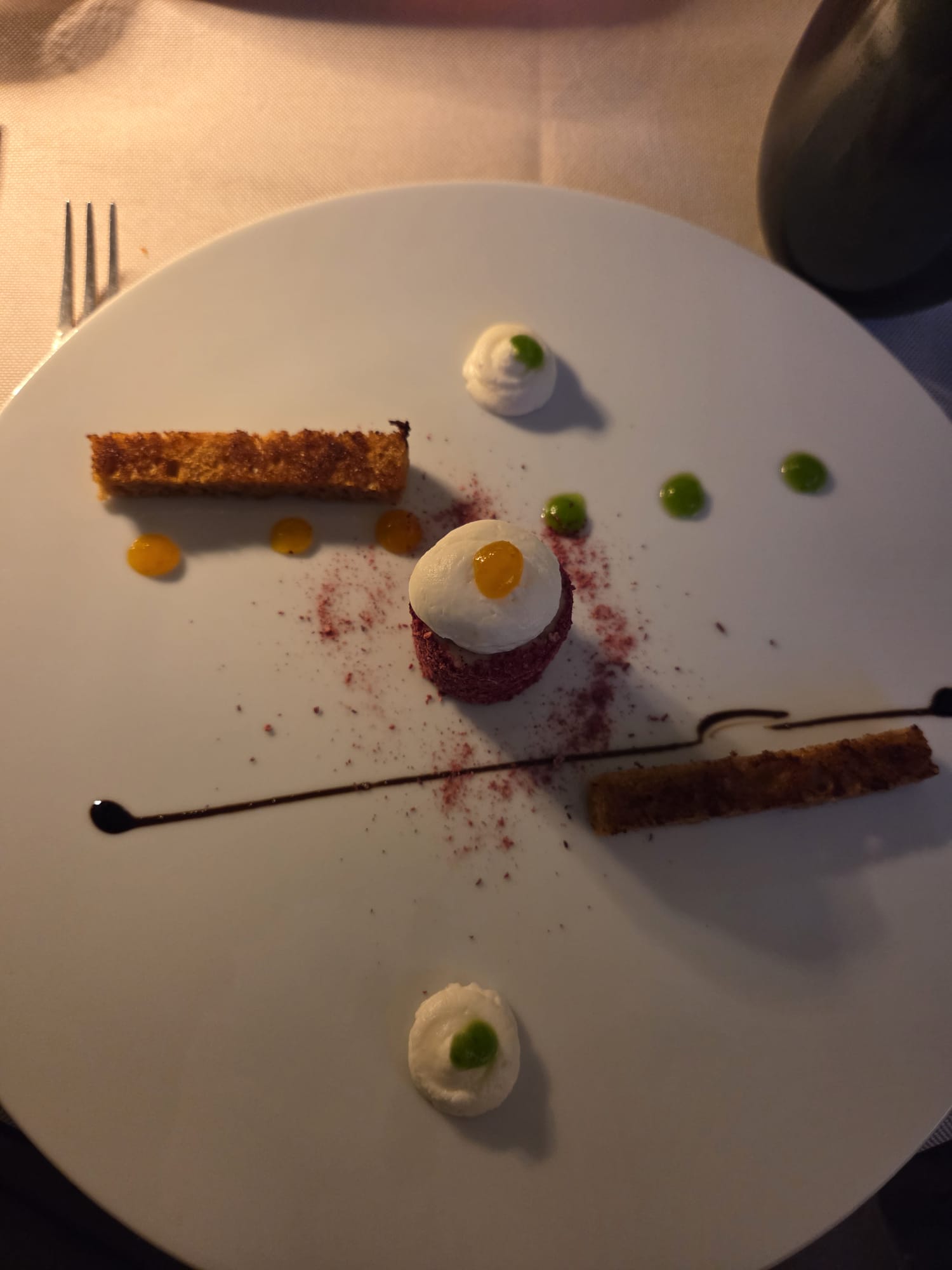 Dessert red velvet décomposé en plusieurs éléments sur assiette blanche, chantilly, points de coulis mangue et herbe, biscuits dorés au Restaurant Guillaume Tell Lavaux
